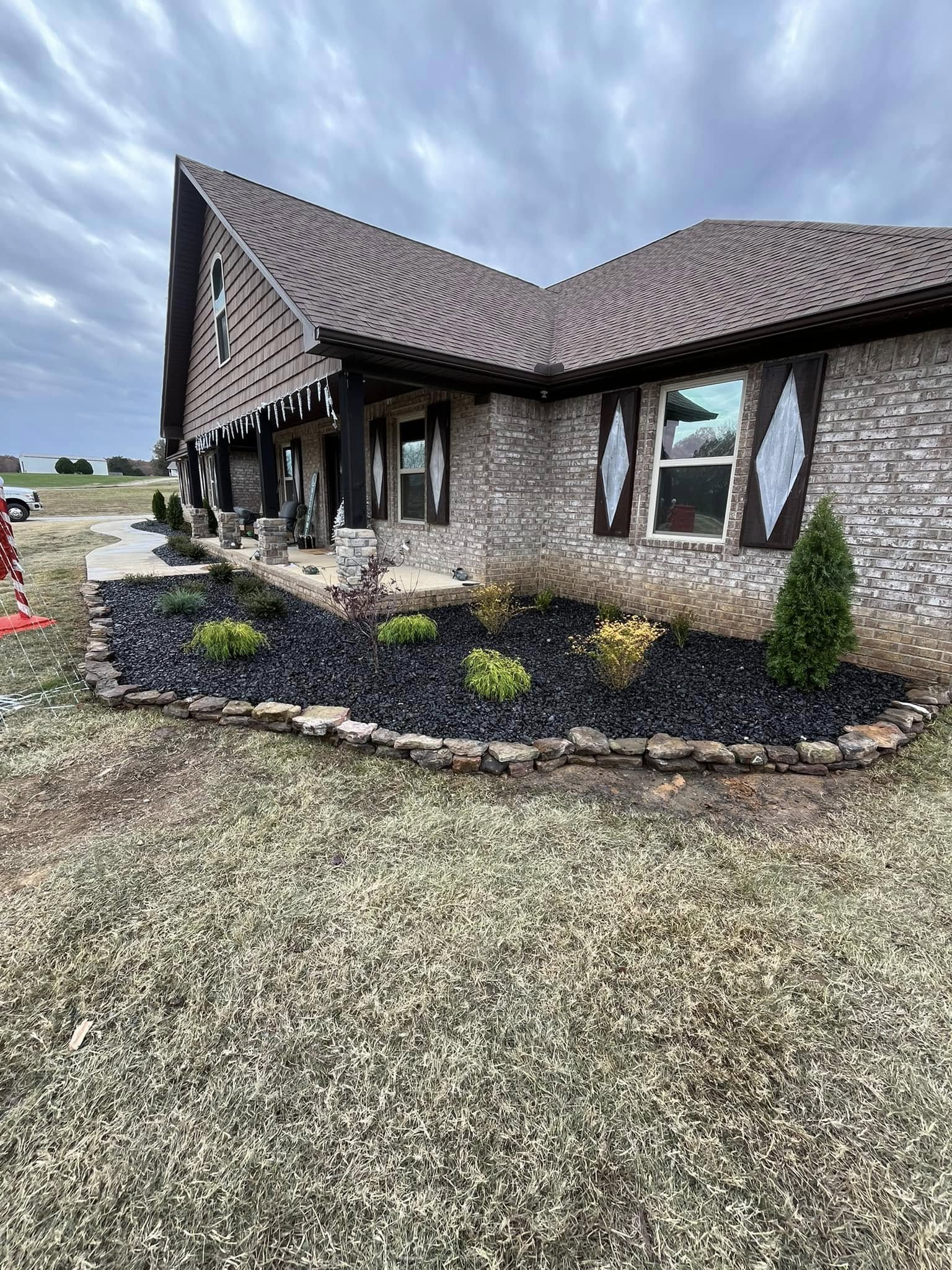 flowerbed with brown mulch and rock border