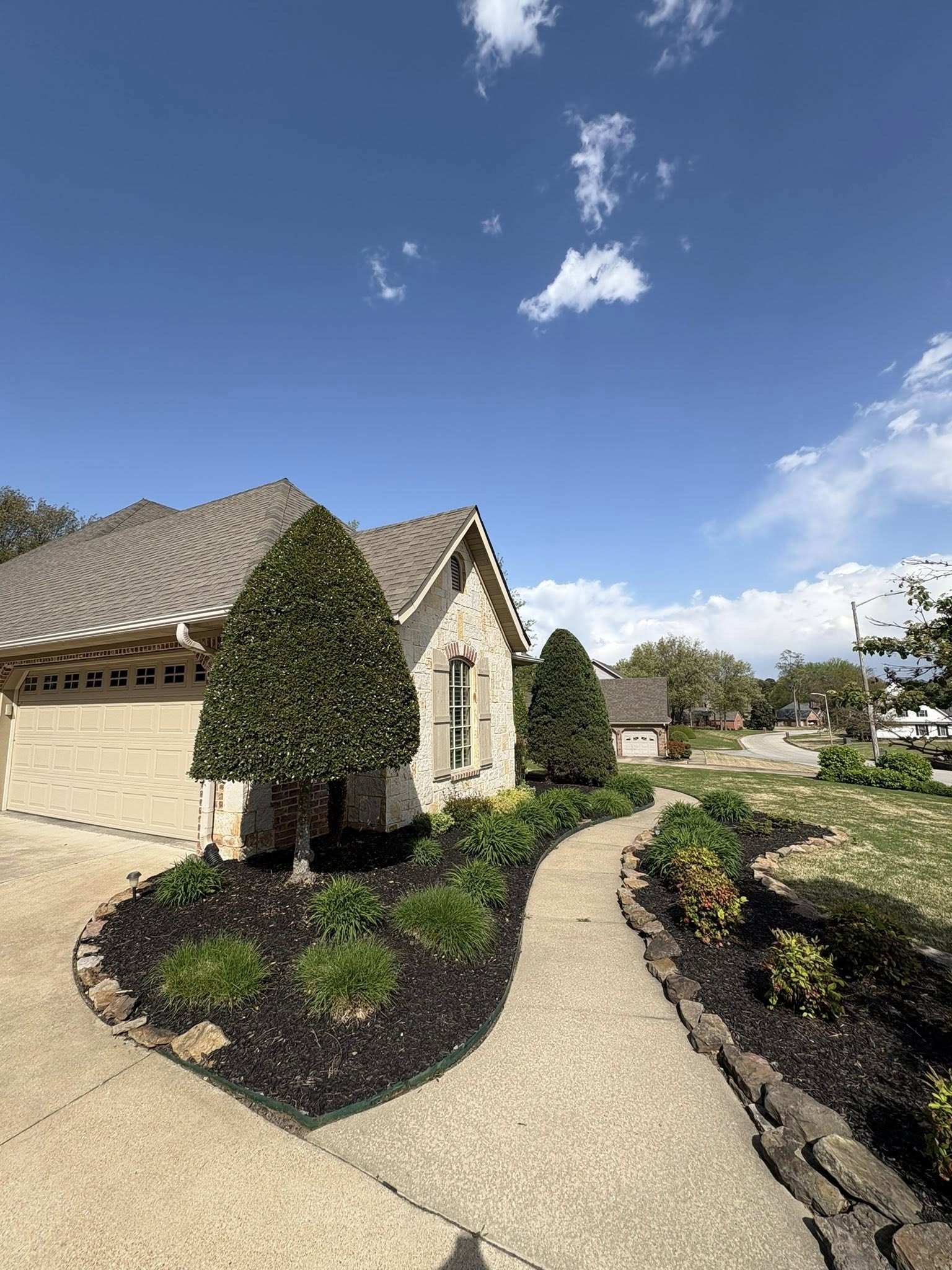 flowerbeds with brown mulch and trimmed trees